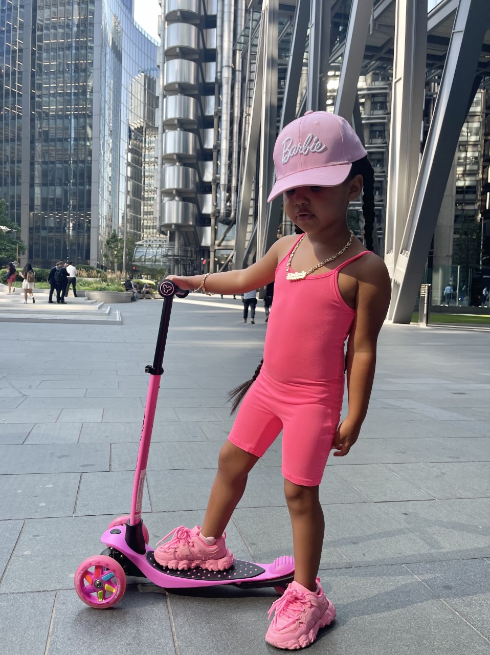 Lynnie is in the city of London with her scooter. Wearing a FashionNova pink onesie and pink sport shoes. She looks simply super cool.