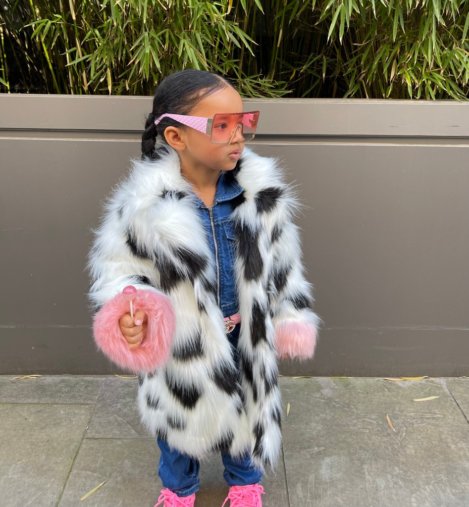 Lynnie is vearing a super trendy fur coat and a denim set. Holding a lolly pop in her hand. Absolutely cuteness overload. Her entire look can be purchased from NovaKids by FashionNova.