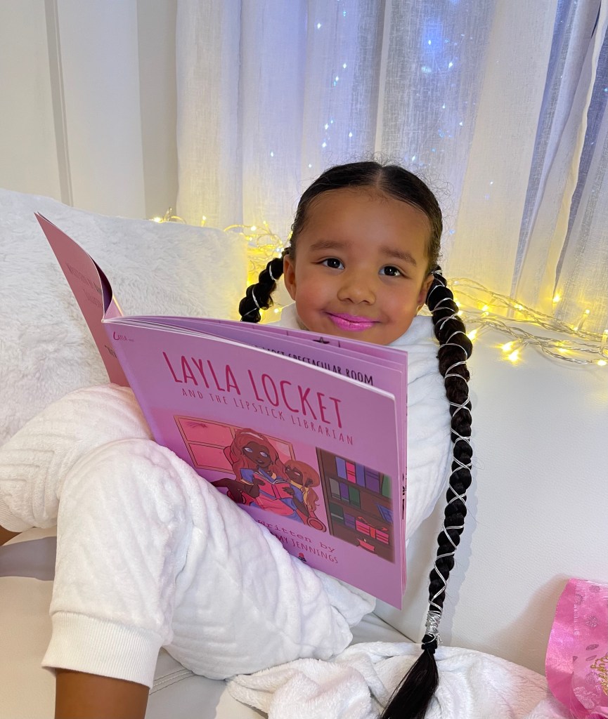 Lynnie is reading Layla Locket. She is put lipstick on her lips, because the book is about a little girl who discovers a lipstick library. 